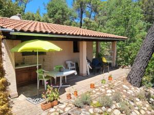a patio with a table and an umbrella at Panoramic lake view in Esparron-de-Verdon