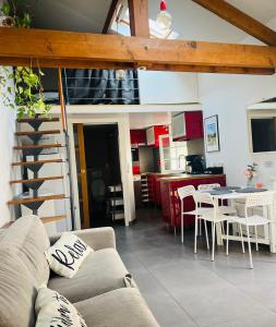 a living room with a couch and a table and a kitchen at Petite maison indépendante à 20min de Paris in Bonneuil-sur-Marne
