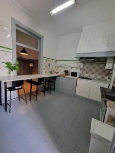 a large kitchen with a table and chairs in it at Rota Ria Alojamento Local in Aveiro