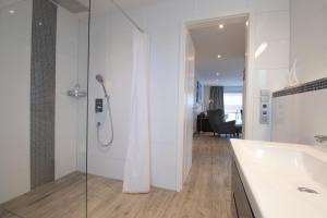 a bathroom with a tub and a shower and a sink at Ferienwohnung Suite Relax - nur 3 Minuten vom Strand entfernt in Scharbeutz +9 photos