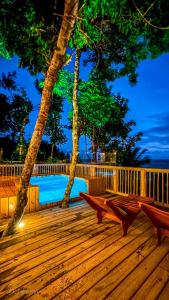 una terraza de madera con 2 bancos y un árbol en TRANCOSO - Casa Vista do Espelho, en Porto Seguro