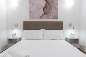 a bedroom with a large white bed with two night stands at AHR Residence Porto Pollo in Porto Pollo