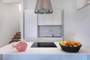 a kitchen with a bowl of fruit on a counter at AHR Residence Porto Pollo in Porto Pollo +30 photos