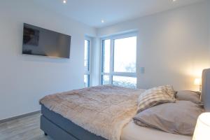 a bedroom with a bed with a large window at Ferienwohnung Suite Relax - nur 3 Minuten vom Strand entfernt in Scharbeutz