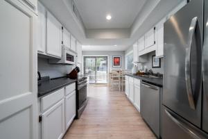a kitchen with white cabinets and stainless steel appliances at 778 Spinnaker Beach House in Seabrook Island