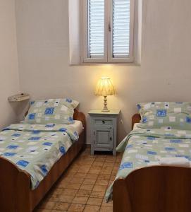a bedroom with two beds and a lamp on a night stand at Apartment Dyonis Perast in Perast +37 photos
