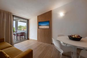 a living room with a table and a dining room at AHR Residence Porto Pollo in Porto Pollo