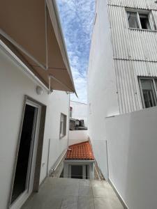 an alley between two white buildings with a red roof at La Marina Apartamentos in O Grove