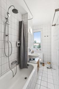 a white bathroom with a tub and a sink at stonehomes - 2 Apartments nahe Goitzschesee in Muldenstein