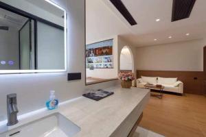 JiawanMountain and Bamboo Holiday Homestay Zhangjiajie Forest Park Branch的带水槽的浴室和客厅