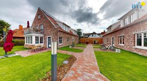 a brick house with a brick pathway in the yard at Haus Christine Ferienwohnung 4 in Langeoog