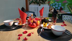 a table with plates of food and bowls of fruit at Chambres d hôtes Léonie in Druillat