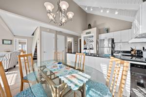a kitchen and dining room with a glass table and chairs at 818 Treeloft Cottage in Seabrook Island