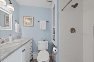 um banheiro branco com um vaso sanitário e uma pia em 818 Treeloft Cottage em Seabrook Island mais 15 fotografias