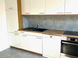 a kitchen with white cabinets and a sink at Ferienhaus mit Terrasse und Garten in Lippstadt +12 photos