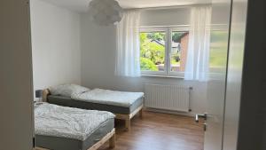 a small room with two beds and a window at Ferienhaus mit Terrasse und Garten in Lippstadt