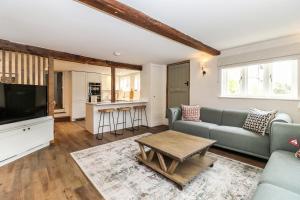 a living room with a couch and a table at Tuffs Farm Cottage in Kings Langley