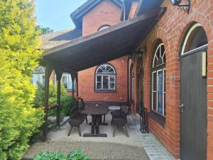 a patio with a table and chairs in front of a brick building at Rent in summer in Ragaciems