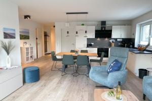 a kitchen and living room with a table and chairs at KÜSTE33/48 – Penthousewohnung mit Dachterrasse, Sauna - strandnah! in Butjadingen OT Tossens