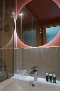 a bathroom with a sink and a mirror at Hôtel Les Bains in Saint-Valery-en-Caux