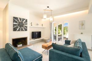 ein Wohnzimmer mit 2 blauen Sofas und einem Kamin in der Unterkunft Villa Olga Corfu by Villa Plus in Kontokali