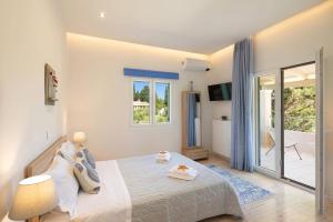 ein Schlafzimmer mit einem Bett und einem Balkon in der Unterkunft Villa Olga Corfu by Villa Plus in Kontokali + 18 Fotos