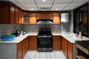 a kitchen with wooden cabinets and a black stove at جناح خاص في أجنحة طيبة مكارم in Medina