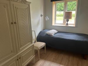 una camera da letto con un letto, una finestra e una sedia di Magasinet Stora Långbro a Tystberga