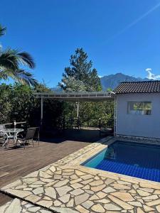 a patio with a pool and a table and a house at Penedo House Pousada in Penedo +23 photos