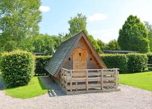 a small wooden cabin with a pitched roof at Wild Rose Holiday Park in Colby