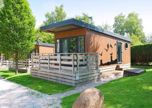 a small cabin with a fence in the grass at Wild Rose Holiday Park in Colby +117 photos