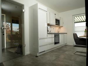 a kitchen with white cabinets and a table at Sonnenweg 4 in Diemelsee