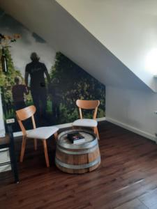 a living room with two chairs and a barrel at LÖSS Wijnhotel en Smaaklokaal in Vijlen