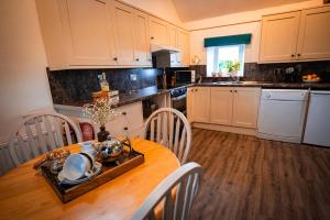 a kitchen with a wooden table with chairs and a dining room at Irfon Cottage in Builth Wells