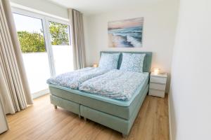 a bedroom with a bed and a large window at KüstenPerle - Penthousewohnung mit 2 Schlafzimmern und Sauna in Butjadingen OT Tossens