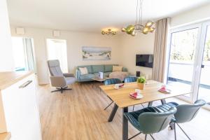 a living room with a table and a couch at KüstenPerle - Penthousewohnung mit 2 Schlafzimmern und Sauna in Butjadingen OT Tossens