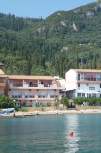 a building on the shore of a body of water at Galini Sea Apartments in Benitses