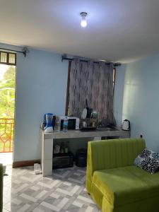 a living room with a green couch and a table at MSF BACHELOR PAd in Arusha +7 photos