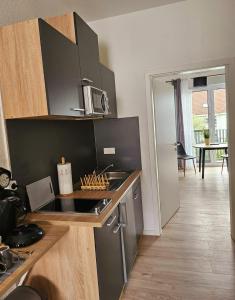 a kitchen with a sink and a stove top oven at Neues Ruhrtal Apartment 3 mit Klimaanlage, Balkon in Wickede (Ruhr)