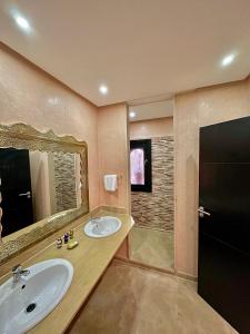 ein Badezimmer mit zwei Waschbecken und einem Spiegel und einer Dusche in der Unterkunft Riad Dar Mima Hnina - Your Traditional and Private haven of peace, 2 pools, 10' from airport in Marrakesch + 15 Fotos
