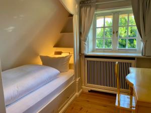 a small room with a bed and a window at Sylt Glück in Morsum