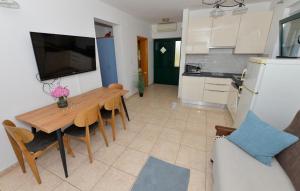 a kitchen and dining room with a table and a refrigerator at Eight-Bedroom Holiday Home In Pasman in Pašman