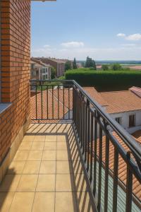 balcón con barandilla y vistas a un edificio en Pension Gelin, en Carrizo de la Ribera