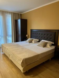 a bedroom with a large bed with a large headboard at SoloApartment in Sunny Beach +22 photos