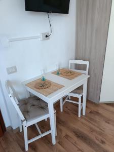 a white table and two chairs with wine glasses on it at Nuovo Alloggio Cisanello in Pisa