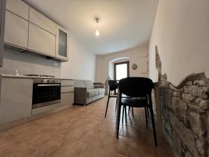 a kitchen with a table and chairs in a room at Sardinian Gallery "S'Iscola" Cozy Stone House in Bosa +10 photos