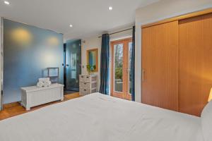 a bedroom with a large white bed and a window at House 36 in Looe +27 photos