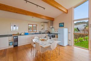 a kitchen with a white table and chairs in a room at House 36 in Looe