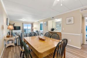 comedor y sala de estar con mesa de madera y sillas en PierView 308, en Nags Head 19 fotos más
