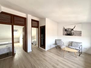 a bedroom with a table and a cow picture on the wall at BaruHaus duplex piscina y parking Villamañán 2 in Villamañán